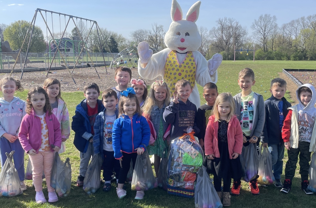 Preschool students on a playground with the Easter Bunny